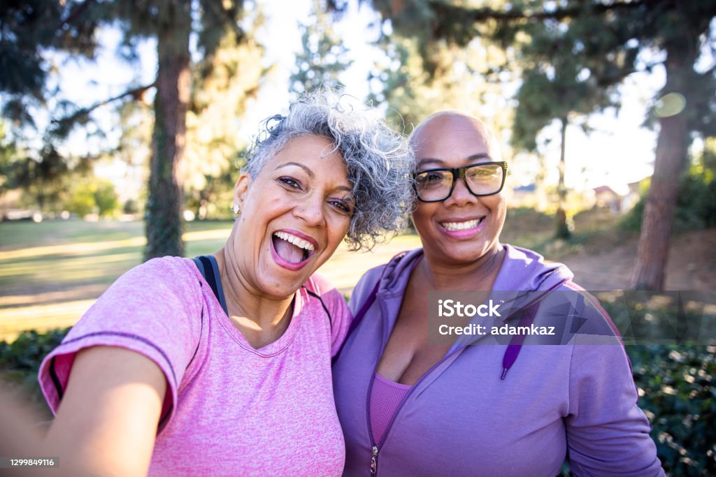 Two best friends taking selfies in the park.